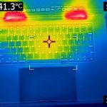 A FLIR image of the keyboard surface of the laptop. The lower half of the image is a medium blue (30 degrees C). The keyboard area has a "V" shape in it, stretching from the top corners to the space bar, which is green (33 C) on the edges and yellow (37 C) in the middle. Around the "V" is light blue. Above the keyboard, where the hinges are located, are two bright red (41 C) spots. There is an indicator which states that the highest temperature is 41.3 degrees celcius.